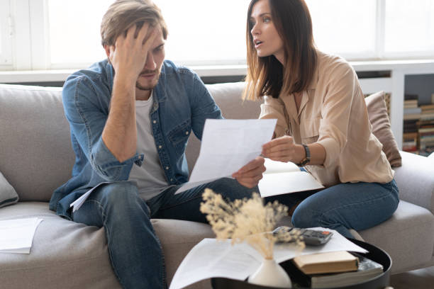 istock Photo of cheerful young couple analyzing their finances with documents 1297217357