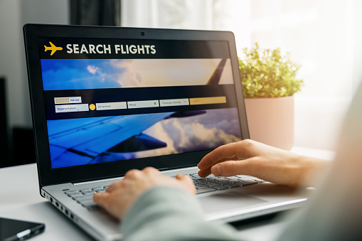 online booking - person using internet website in laptop for flight search and reservation