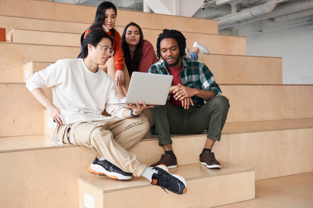 istock Group of international students looking at laptop at school 1297220161