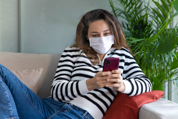 istock Young woman with protect mask and using smartphone 1297220374