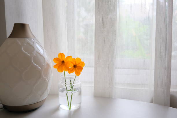 istock Orange flowers on the table near window. 1297222678