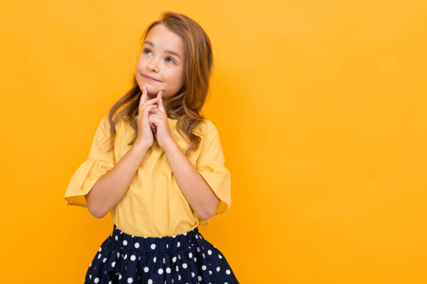 istock stylish young girl posing isolated on a yellow studio background 1297227530