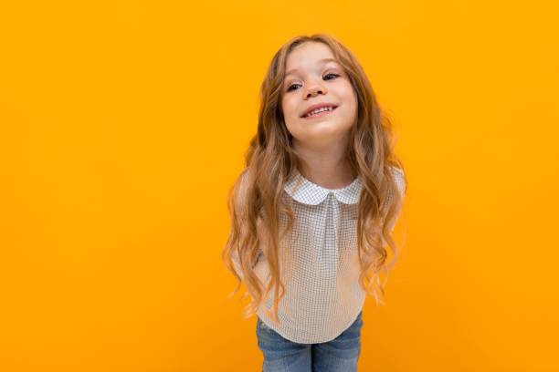 istock stylish young girl posing isolated on a yellow studio background 1297227535