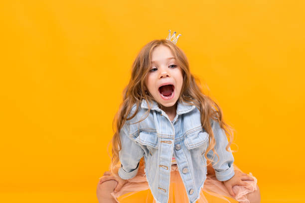 istock stylish young girl posing isolated on a yellow studio background 1297227545