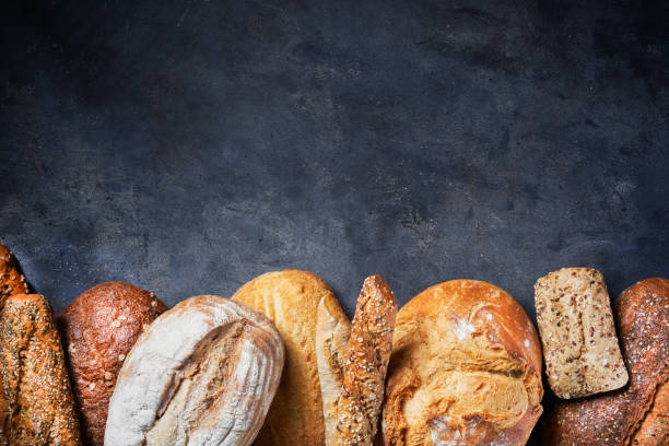 istock Background with Different Types of Bread on dark surface. Close up. Bakery concept. Empty space for text. 1297232065