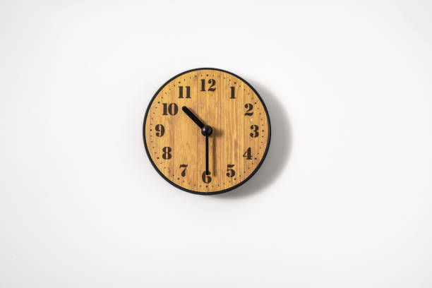 wood office wall clock with white dial on white background. wall clock on white background, top view.