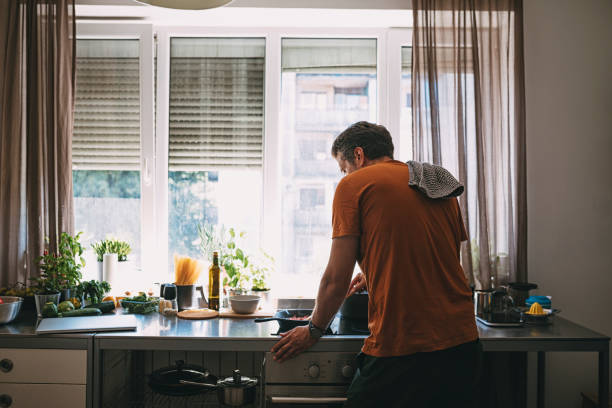istock Handsome Young Man Mixing Vegetables in a Frying Pan 1297236886