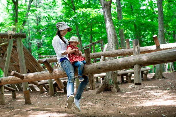 Mother and daughter playing in the forest park