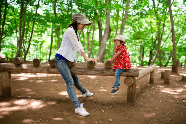 istock Mother and daughter playing in the forest park 1297237432
