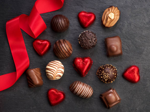 sucrerie de chocolat avec le ruban rouge, vue supérieure, plate laïe - valentines day candy chocolate candy heart shape photos et images de collection