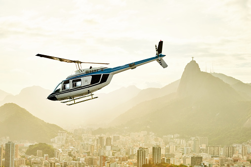Shot of a helicopter flying above Rio de Janeiro Brazil with Corcovado and Christ the Redeemer statue seen in the background
