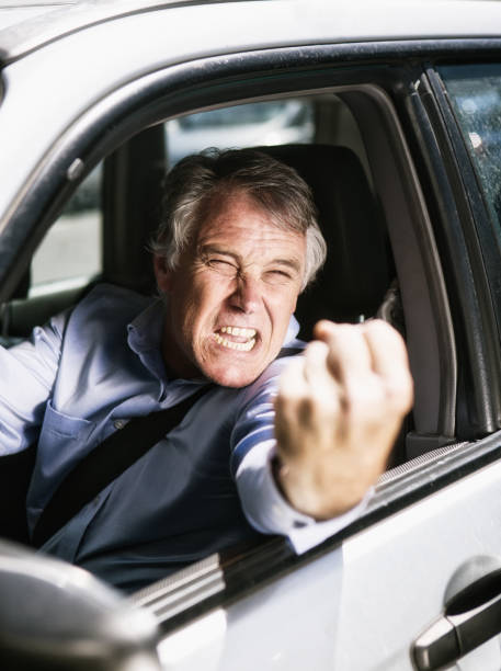 autista furioso scuote il pugno in un attacco di rabbia stradale - shaking fist foto e immagini stock