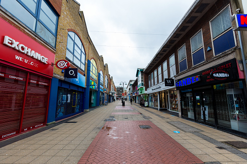 Crawley, UK - 19 January, 2021: the town centre of Crawley, West Sussex, UK, in the middle of lockdown during the covid pandemic at the end of 2020. The town centre is very quiet, with most shops shut, and people wearing face masks and social distancing.