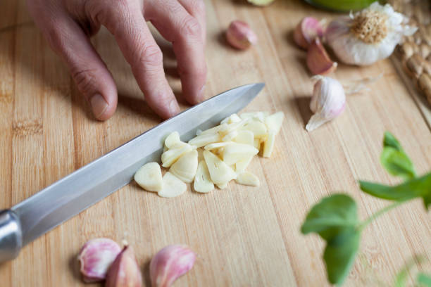 istock Chopping garlic activity -  male cook is slicing the garlic cloves. 1297241663