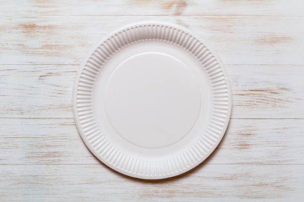 Disposable paper plate on wood background, eco-friendly stock photo