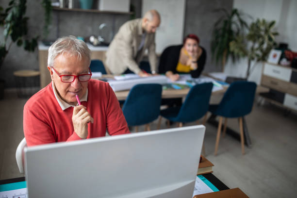 istock Senior architect working on new project in office 1297243658