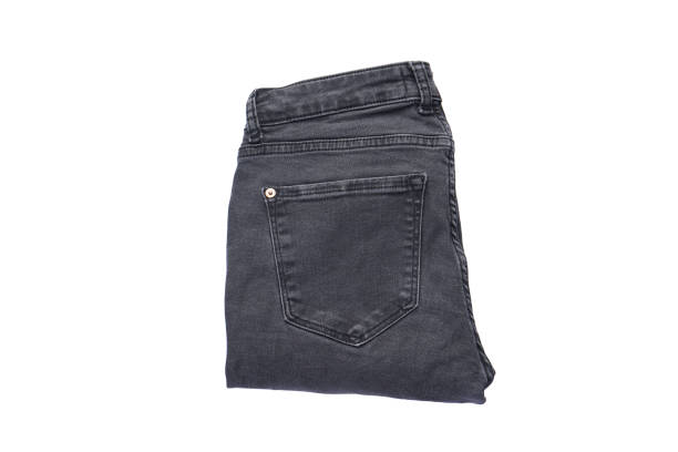 istock Denim pattern, gray jeans isolated on white background. Folded jeans, top view. 1297243695