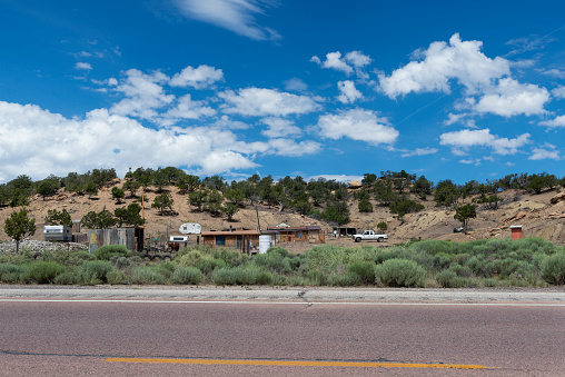 New Mexico, USA - July 15, 2014: A small poor farm with precarious constructions, along a road in a rural area of the State of New Mexico, USA.