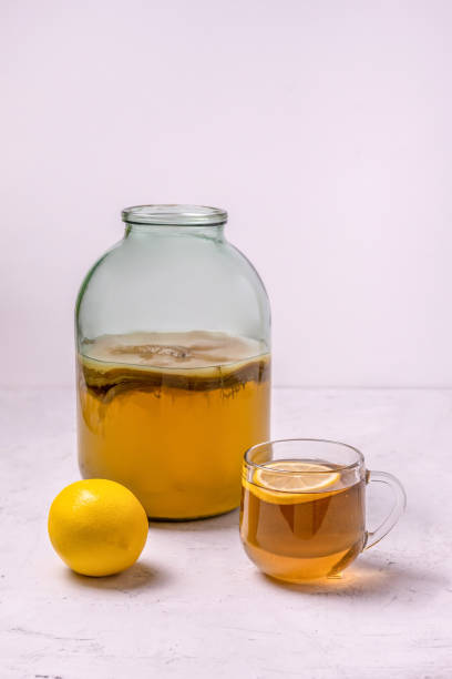 istock kombucha in a glass jar and lemon on a concrete background 1297246641