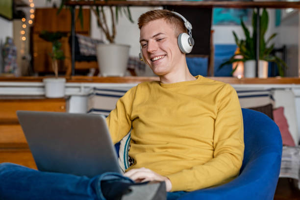 istock Young man at home, using laptop and smiling 1297247889