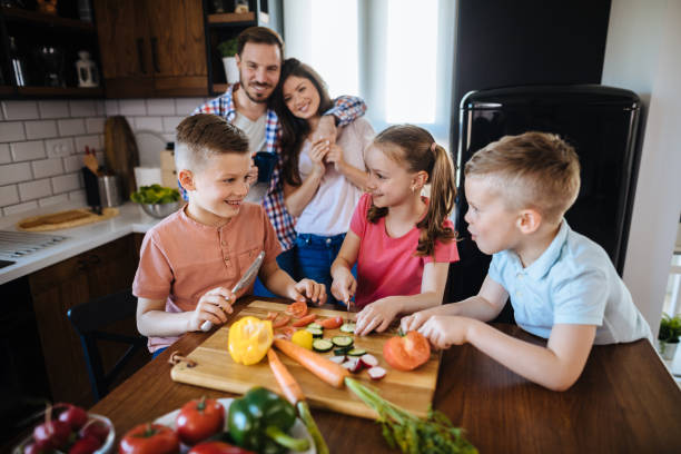 istock Children preparing vegetable salad in the kitchen 1297248135