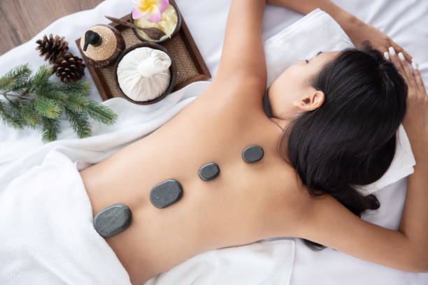 vista de la mujer asiática que recibe el masaje de terapia de roca en spa - massage stones fotografías e imágenes de stock