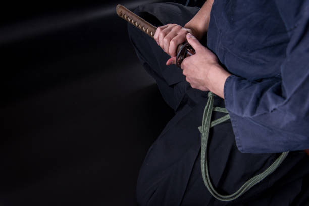 istock A seated man holding his sword with one hand. 1297249814
