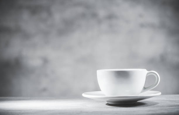 istock Tea cup on gray table and background, front view. White teacup. Blank free space for your advertising or text 1297251138