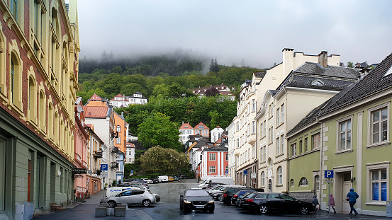 Bergen, Norway - May 5, 2019: The historic colored buildings in the Norwegian city of Bergen brighten the neighborhood during a foggy wet day