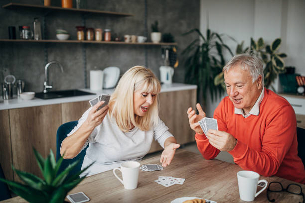 istock Senior couple having fun playing cards at home 1297252198