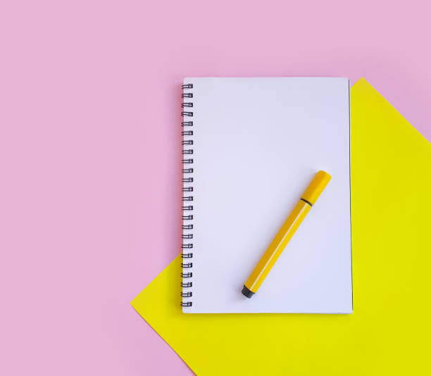 istock notebook, felt-tip pen on a background of colored paper 1297252443