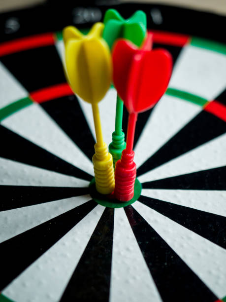 vertical closeup shot of a dartboard with three darts on the bulls eye - target sport target target shooting bulls eye imagens e fotografias de stock