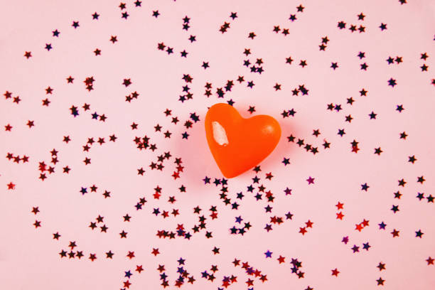 istock decorative volumetric heart on a pink background with confetti and sparkles. view from above. concept of the holiday of all lovers. Valentine's Day 1297253512