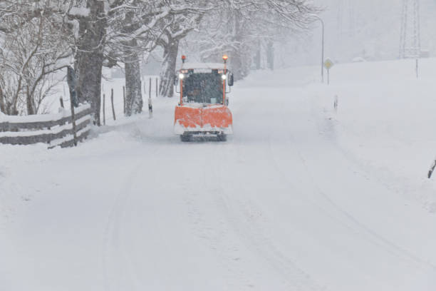 Snowplow on a country road of a small village Snowplow on a remote country road of a small village. winterdienst stock pictures, royalty-free photos & images