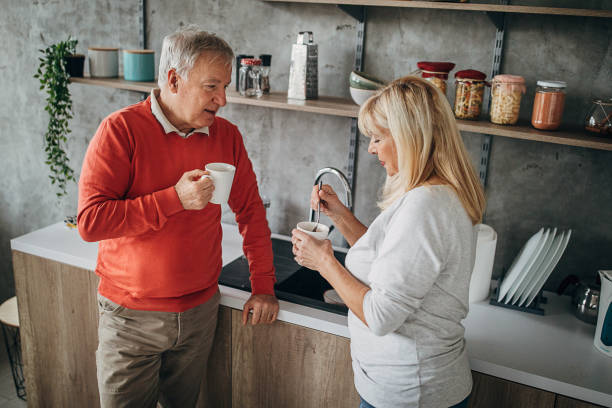istock Senior couple drinking coffee at home 1297253736