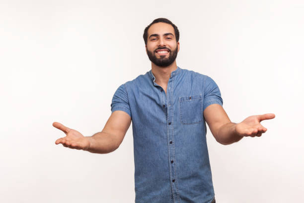 istock Open hearted generous man with beard sharing opening hands looking at camera with kind smile, greeting and regaling, happy glad to see you 1297255373