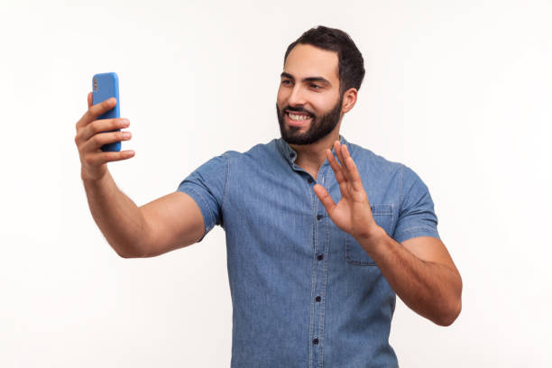 positive bearded man smiling making selfie on smartphone camera, blogger communicating, recording video for followers in social networks - made man object imagens e fotografias de stock