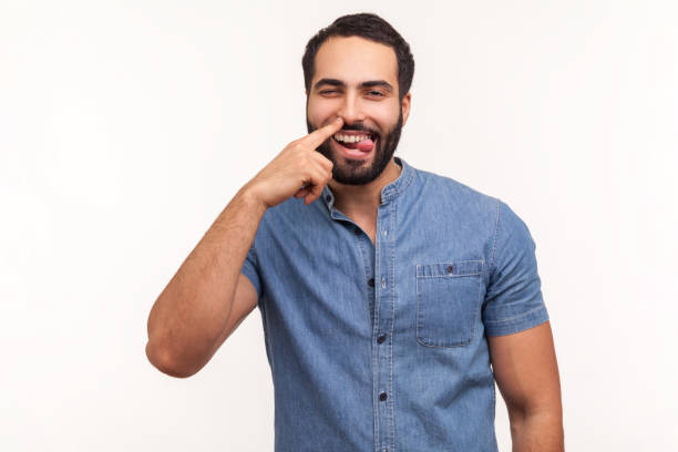 homme comique drôle avec la barbe choisissant le doigt au nez et montrant la langue, regardant l’appareil-photo avec le sourire, ayant l’amusement, dupe autour, mauvaises manières - poking nose in photos et images de collection