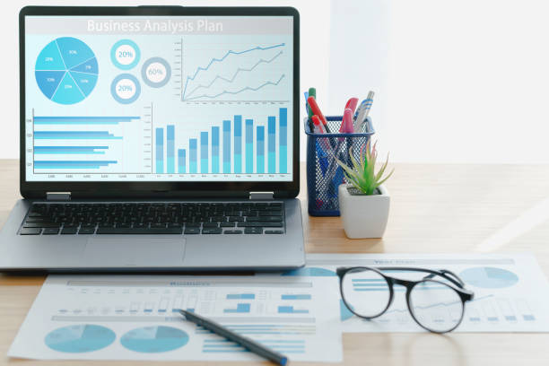 istock Laptop with business financial statistics on a desktop 1297256027