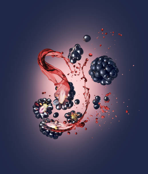 Whole and sliced blackberries with splashes of juice on a blue background