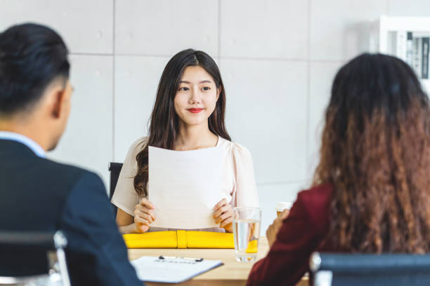젊은 아시아 여성 졸업생 이력서 문서를 들고 회의실에서 긍정적 인 움직임으로 면접을 시작하기 전에 두 명의 관리자에게 준비, 비즈니스 채용 신입 회원 개념 - 취업 면접 뉴스 사진 이미지