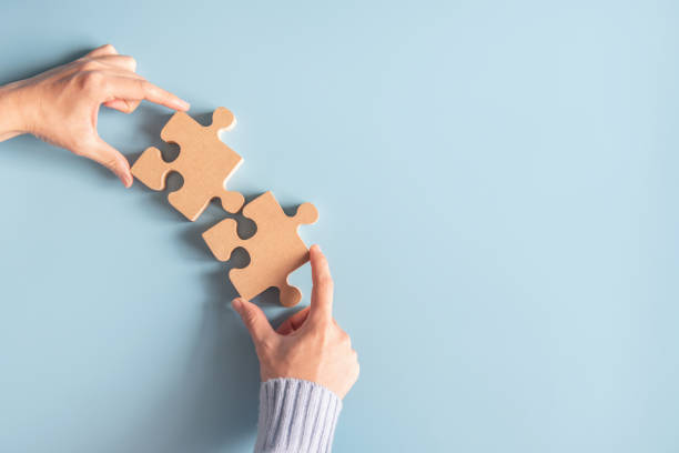 istock Two hands holding jigsaw, Concept for teamwork Building a success. 1297257767