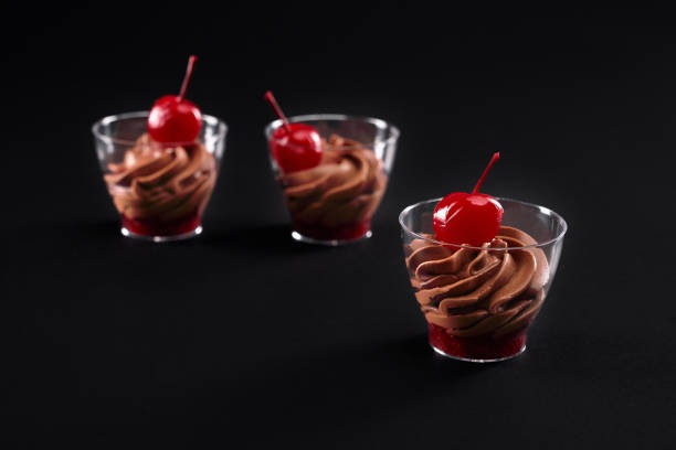 istock Whipped cream and jam in glasses isolated on black. 1297258343