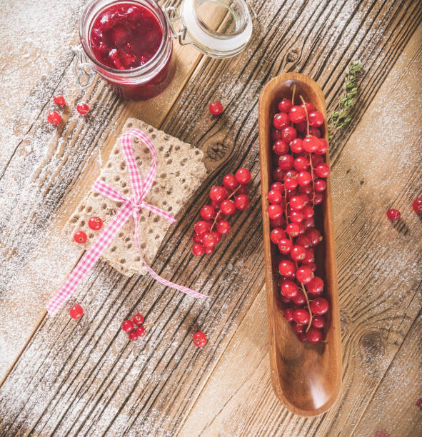 Red berries  with toast on wooden plate at retro concept.