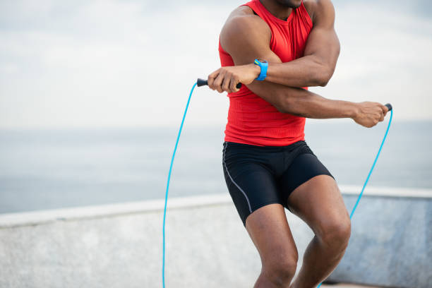 istock Black male runner jumping rope for warming up 1297260073
