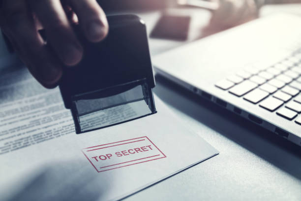 hand put a top secret stamp on document. confidential information concept