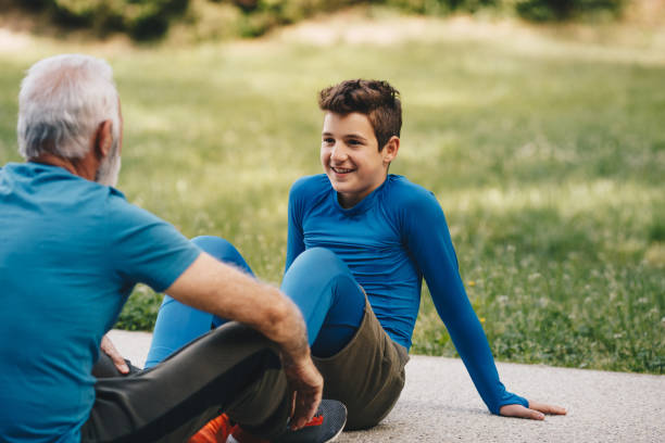 istock Young boy is sitting with his granddad on treadmill, resting. 1297262452