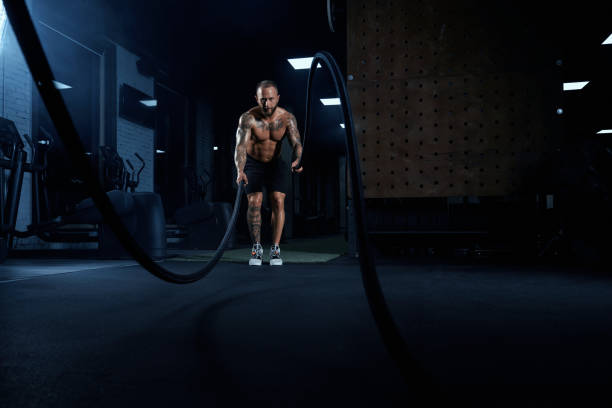 istock Muscular sportsman training with ropes. 1297263143
