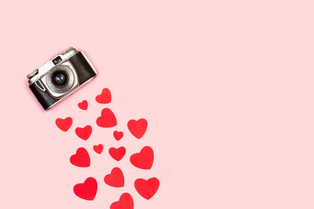 istock A vintage camera with red hearts on a pink background 1297263725