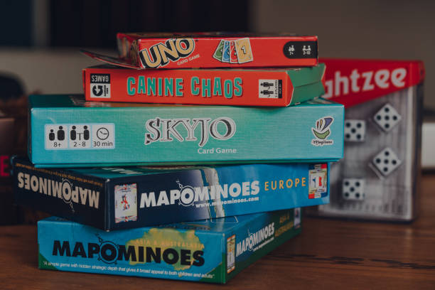 Stack of modern and classing board games on a table. Combe St Nicholas, UK - July 25, 2020: Stack of modern and classing board games on a table. Sales of board games skyrocketed during the Coronavirus pandemic-related lockdowns. board game stock pictures, royalty-free photos & images